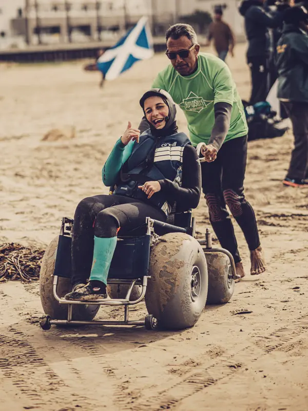 an adaptive surfer in a beach wheelchair